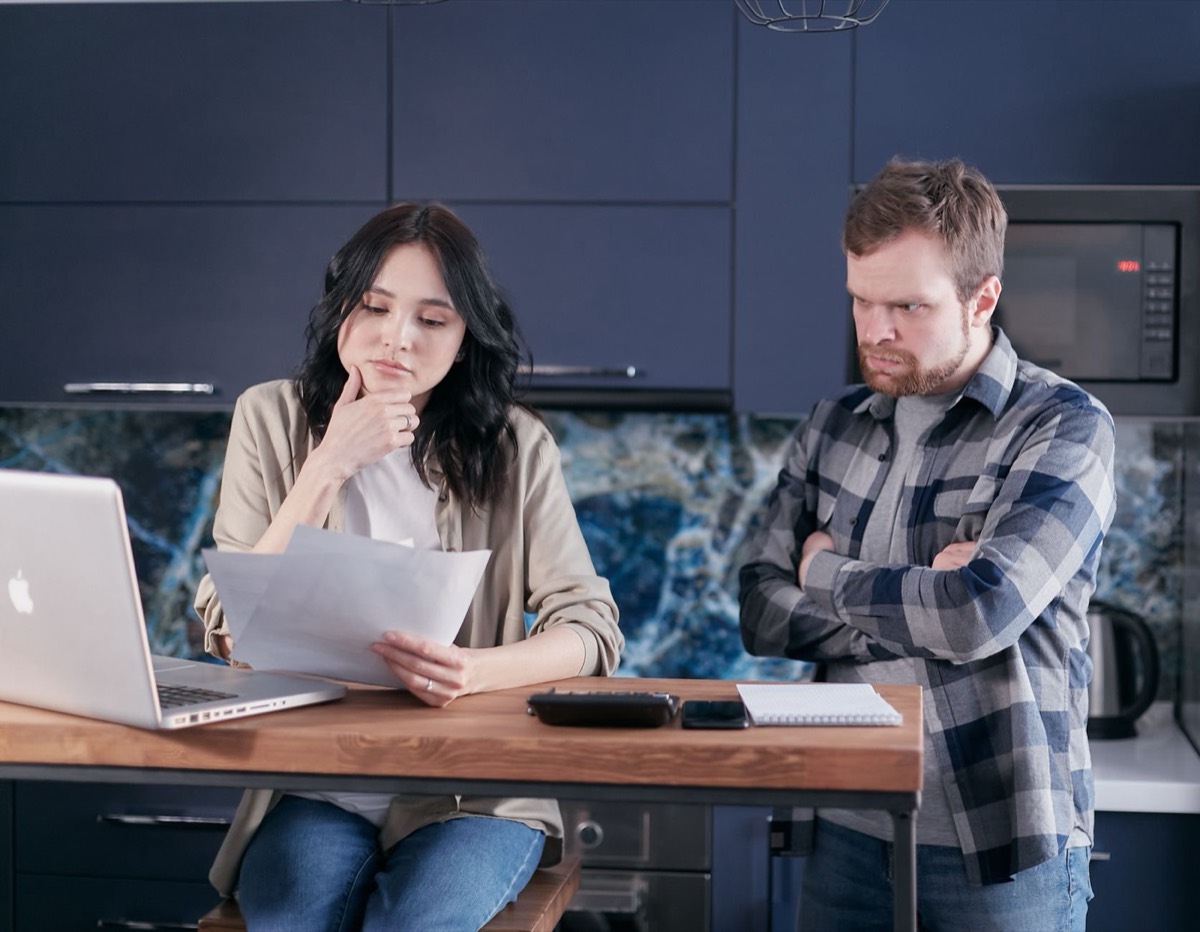 Couple reviewing paycheck and bills after an IRS wage levy, stop wage garnishment in 24 to 72 hours
