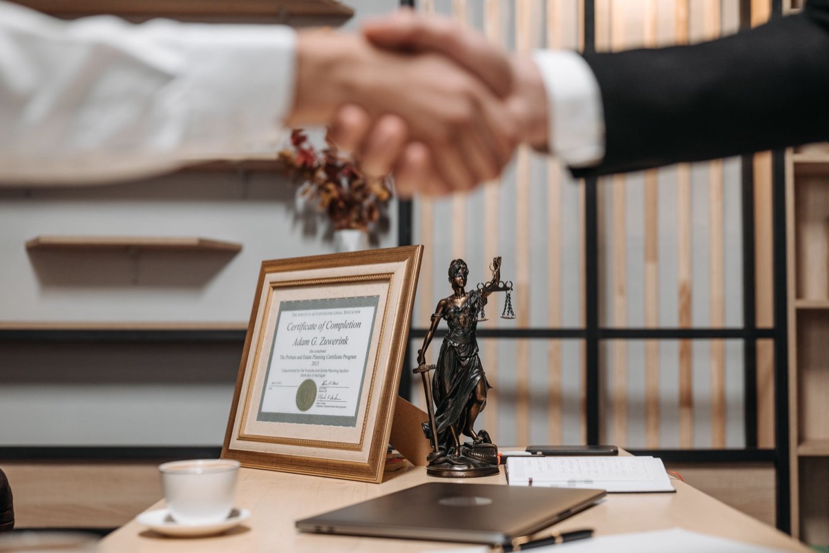Tax attorney shaking hands with client after IRS offer in compromise engagement, settle IRS tax debt for less in Corpus Christi TX